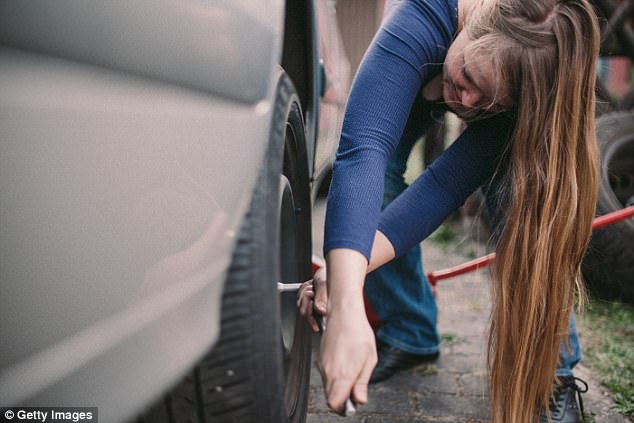 Jeune femme qui change un pneu crevé